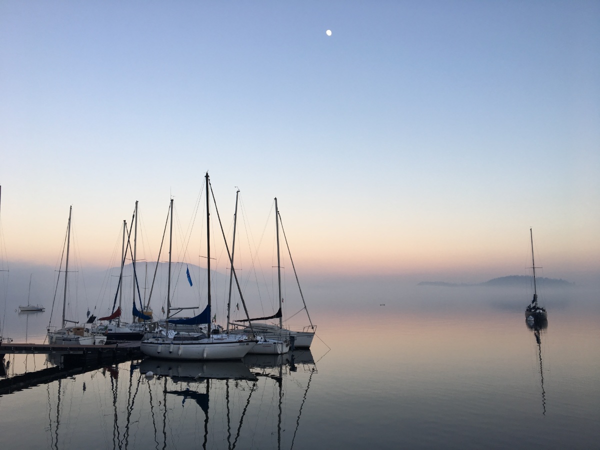 A yacht arriving safely into a tranquil, calm harbour (Credit: Umberto Gorni, Unsplash)